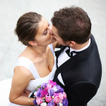 Beautiful picture of a nice young married couple kissing on a street