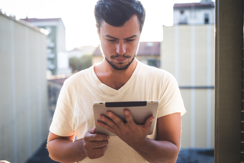 Yuong stylish hipster man using tablet